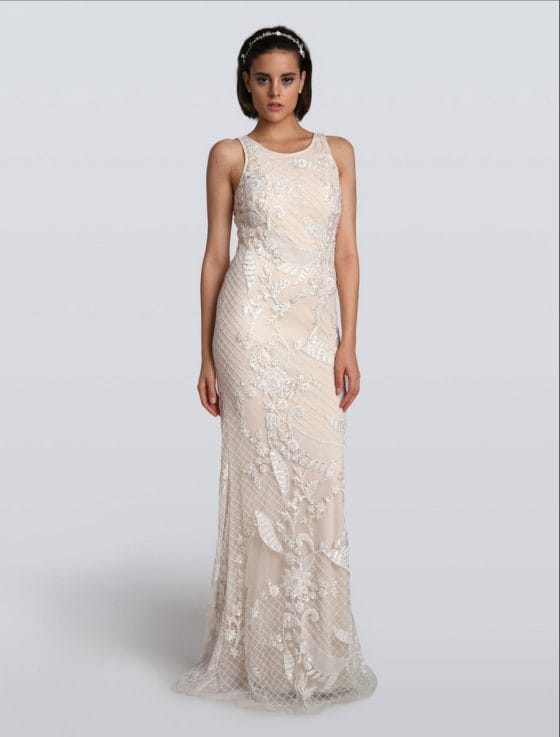 This incredible Carmen Marc Valvo Evelyn C90071 wedding dress is Brand New!  The workmanship on this gown is out of this world!  Intricate detail from top to bottom!  It is made from beaded and embroidered tulle with a soft stretch jersey lining.  The beading and embroidery create a floral and lattice design.  This Evelyn gown is sleeveless with a scoop neckline, a sheath silhouette, a high / sheer back and a chapel length train.