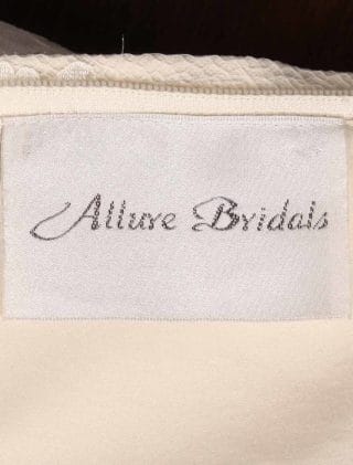 This Allure C341 wedding dress is Brand New and has its hang tag attached!  The workmanship on this gown is amazing in person!  The beading and embroidery on the bodice are out of this world!  Luxurious lace creates the fit and flare design of this Allure wedding gown.  The light gold lining shows through giving the gown a soft touch of color.  There are sheer short sleeves, a sheer back, an empire waist and a trumpet silhouette that flows into a chapel train.